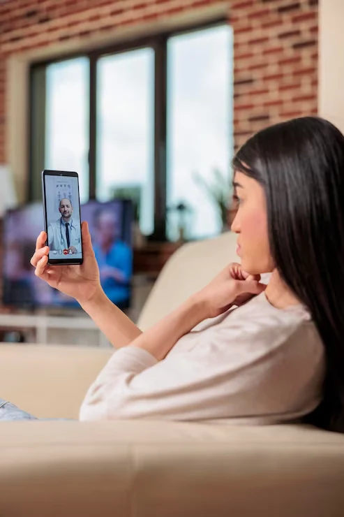 Mulher em casa conversando com um médico pela tela do celular
