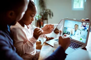 Família acompanhando uma teleconsulta por computador